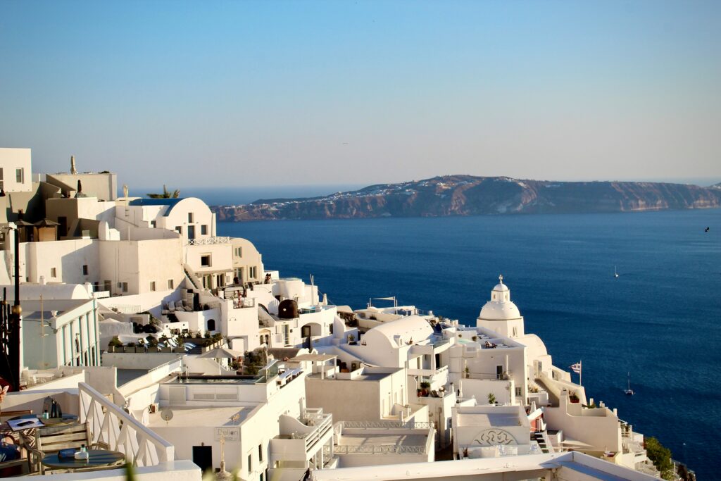 Whitewashed buildings overlooking the Santorini caldera at sunset.